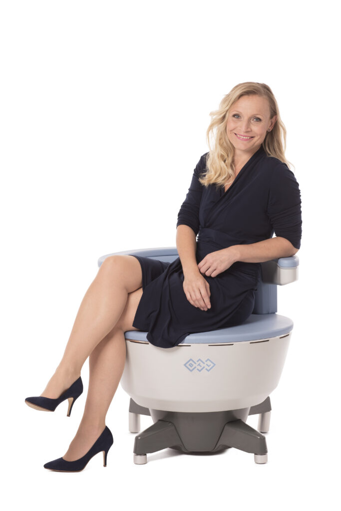 Woman sitting on the Emsella device